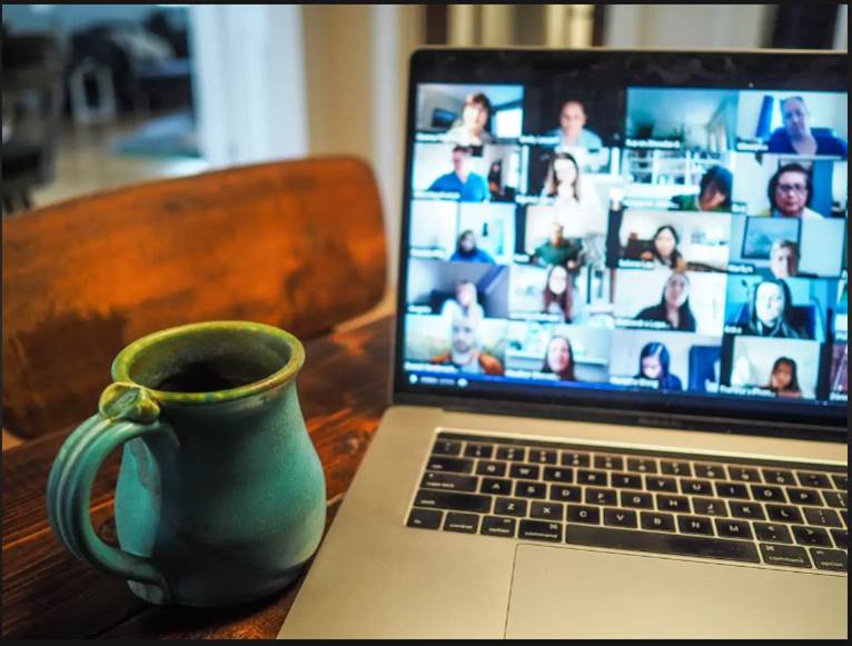 Foto de una reunión de zoom con taza de café y ordenador portátil